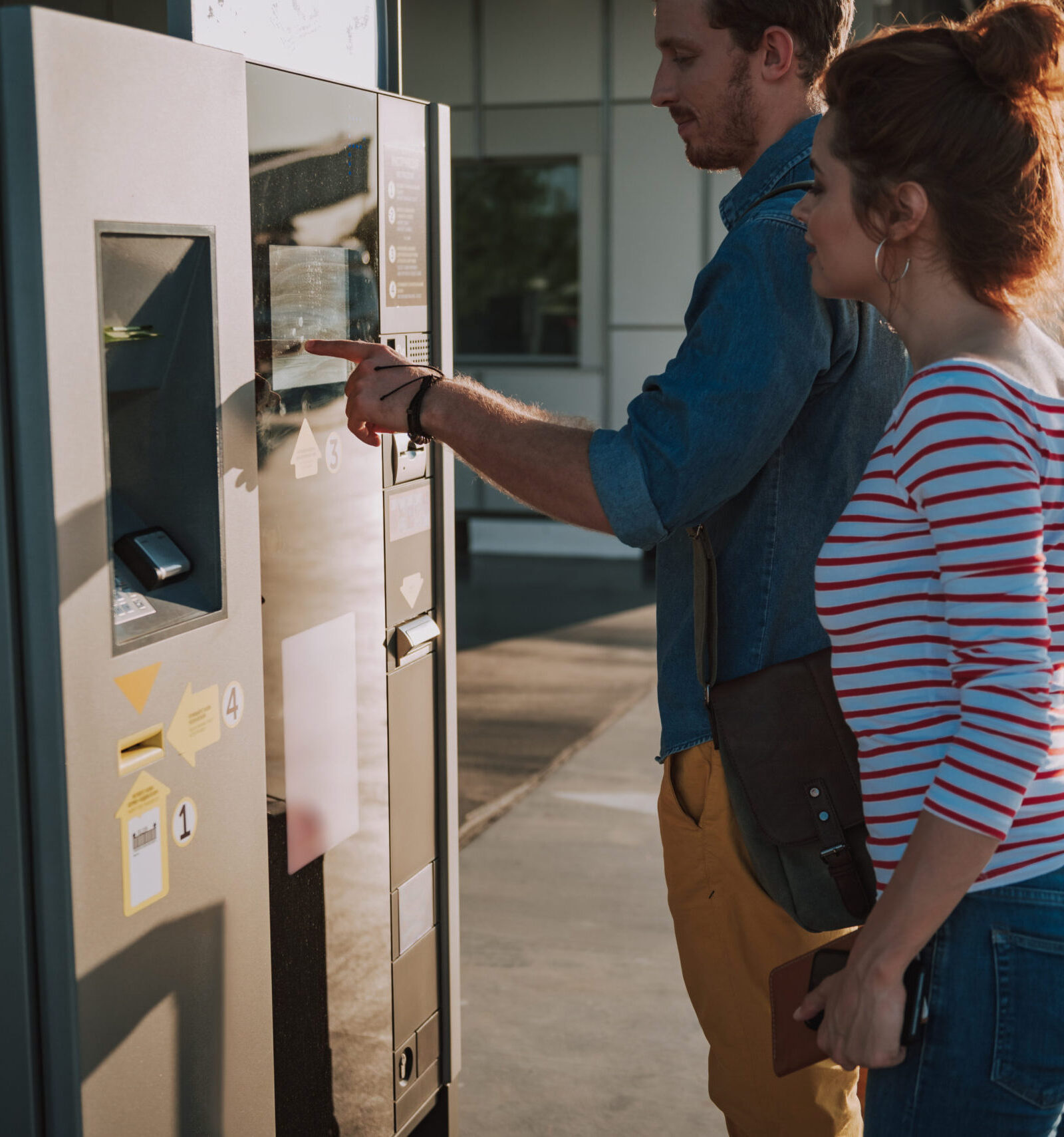 airport parking consultants picture of couple at airport parking using terminal parking ticket kiosk machine for self-service payment